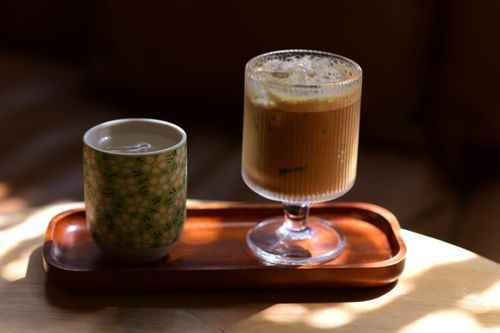 Free Aesthetic shot of a coffee and tea set on a wooden tray, capturing warm natural light and moody shadows. Stock Photo