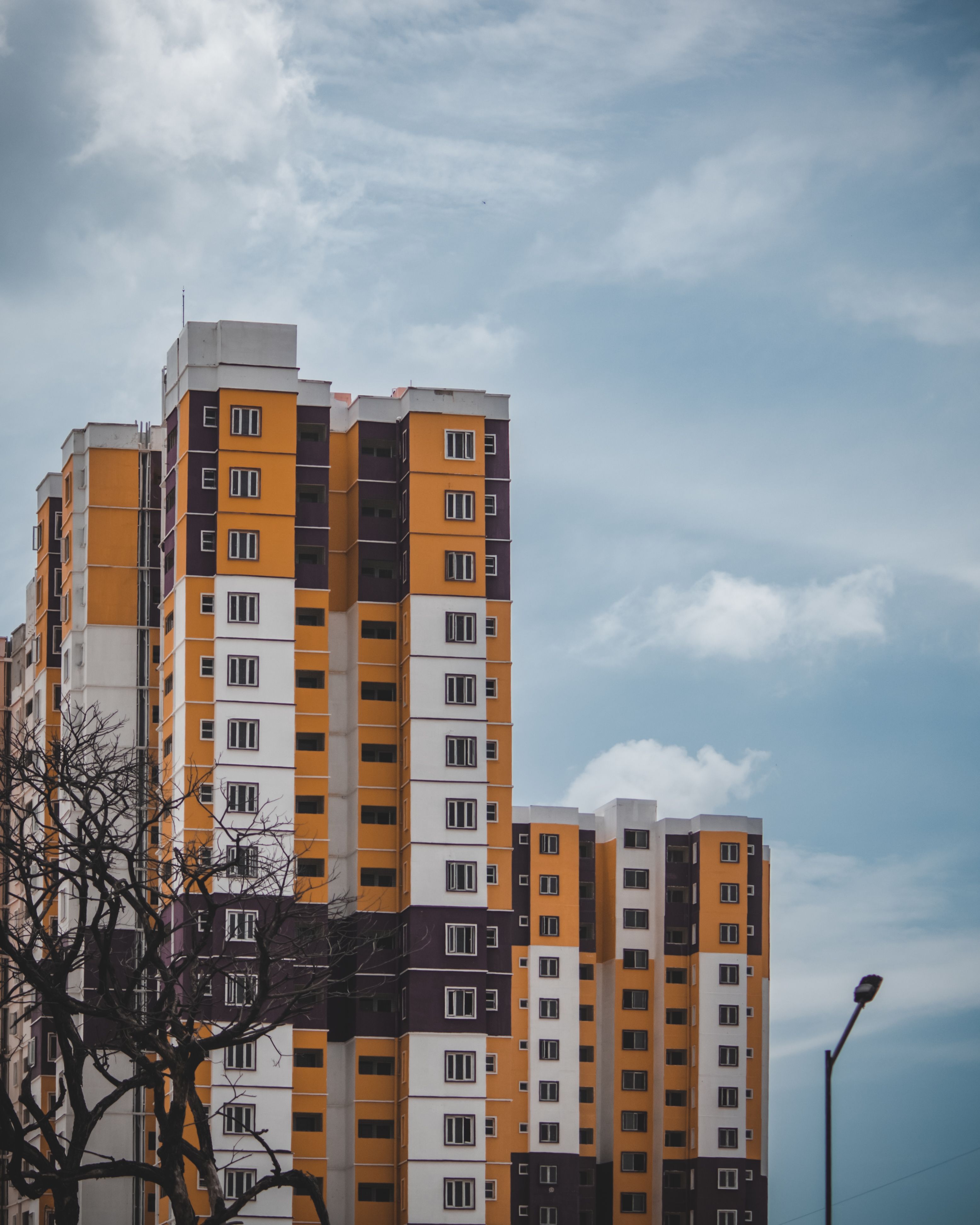 Colorful High-rise Buildings Against Cloudy Sky · Free Stock Photo