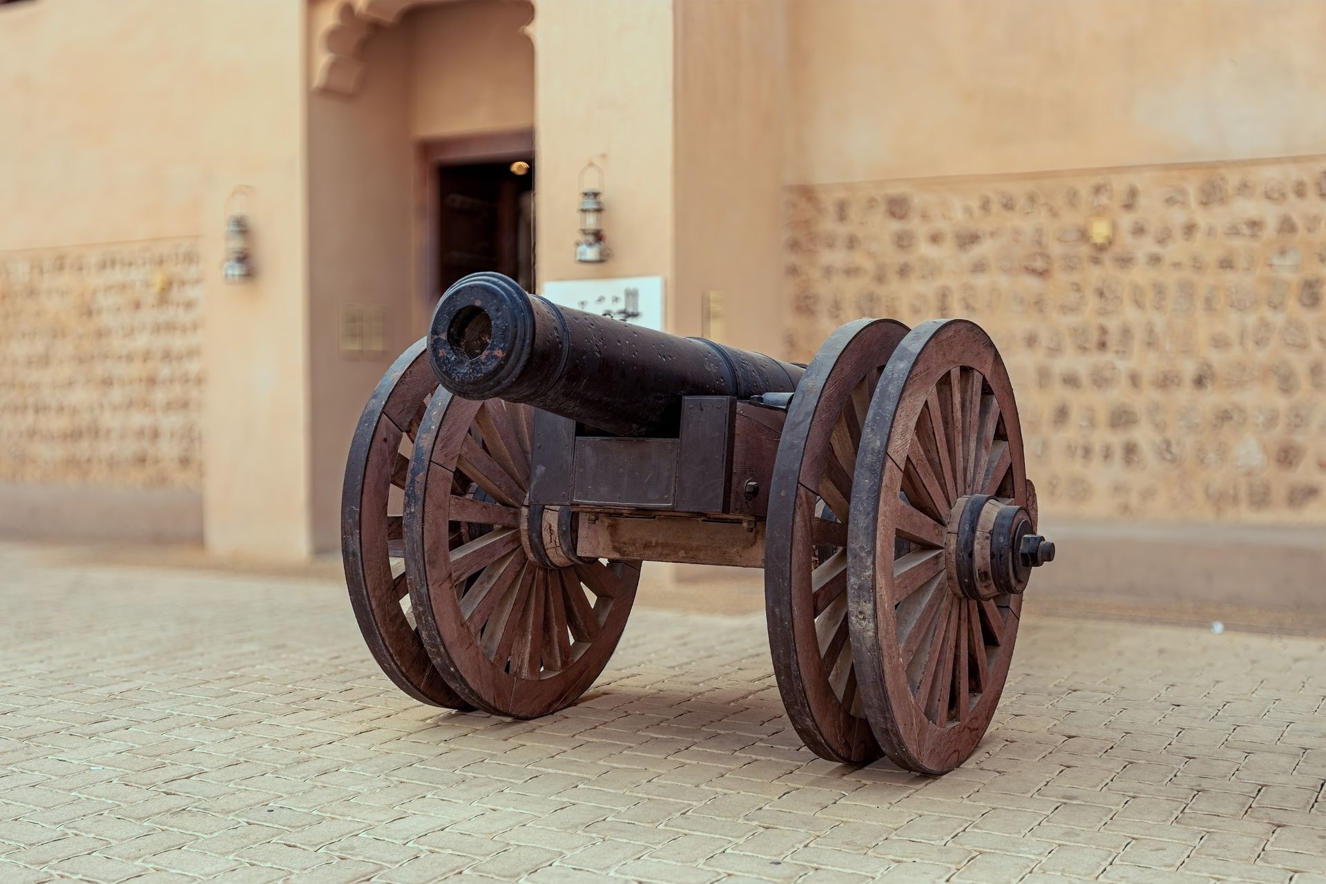 Vintage cannon displayed outdoors at a museum in Sharjah, UAE, showcasing historical artillery.