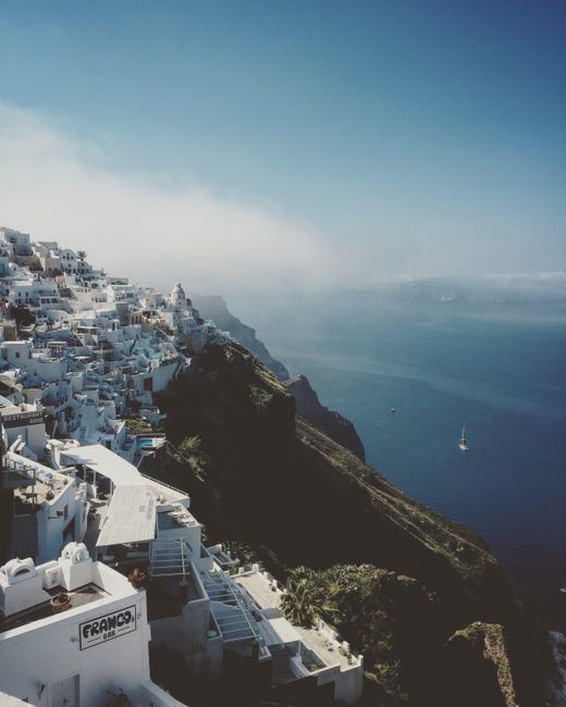 Stunning aerial view of Santorini's iconic white buildings atop cliffs overlooking the Aegean Sea.
