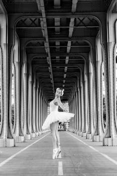 Elegant ballerina dancing under a bridge in Paris, France, showcasing grace and poise.