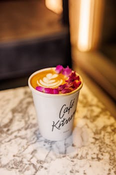 A beautifully crafted latte topped with rose petals at Café Kitsuné, creating a chic coffee experience.
