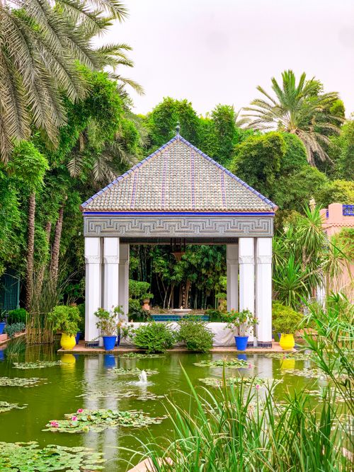 Free Stunning pavilion surrounded by lush greenery and a peaceful lily pond in Marrakesh, Morocco. Stock Photo
