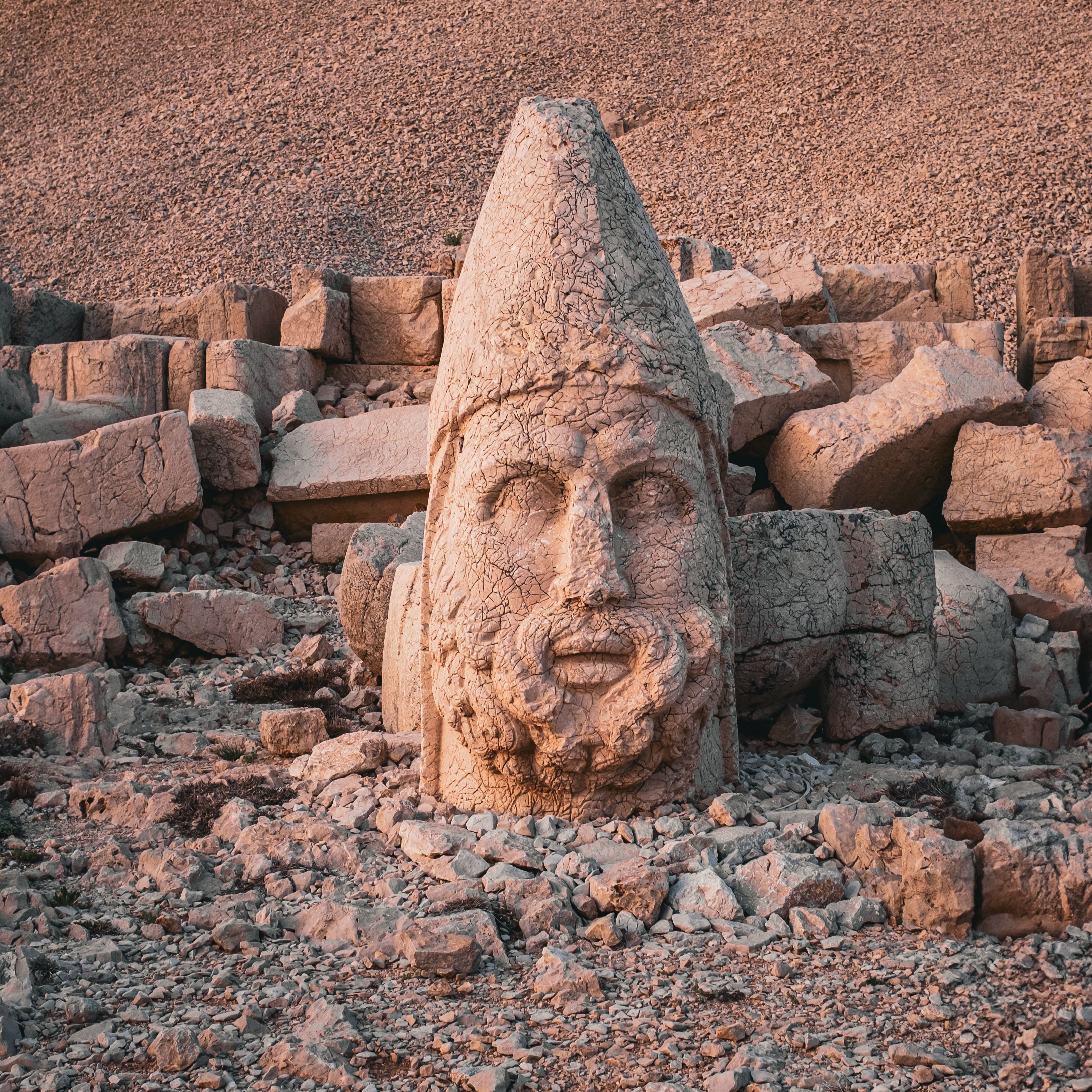 Majestic ancient stone head on Mount Nemrut, Turkey in the warm glow of sunset.