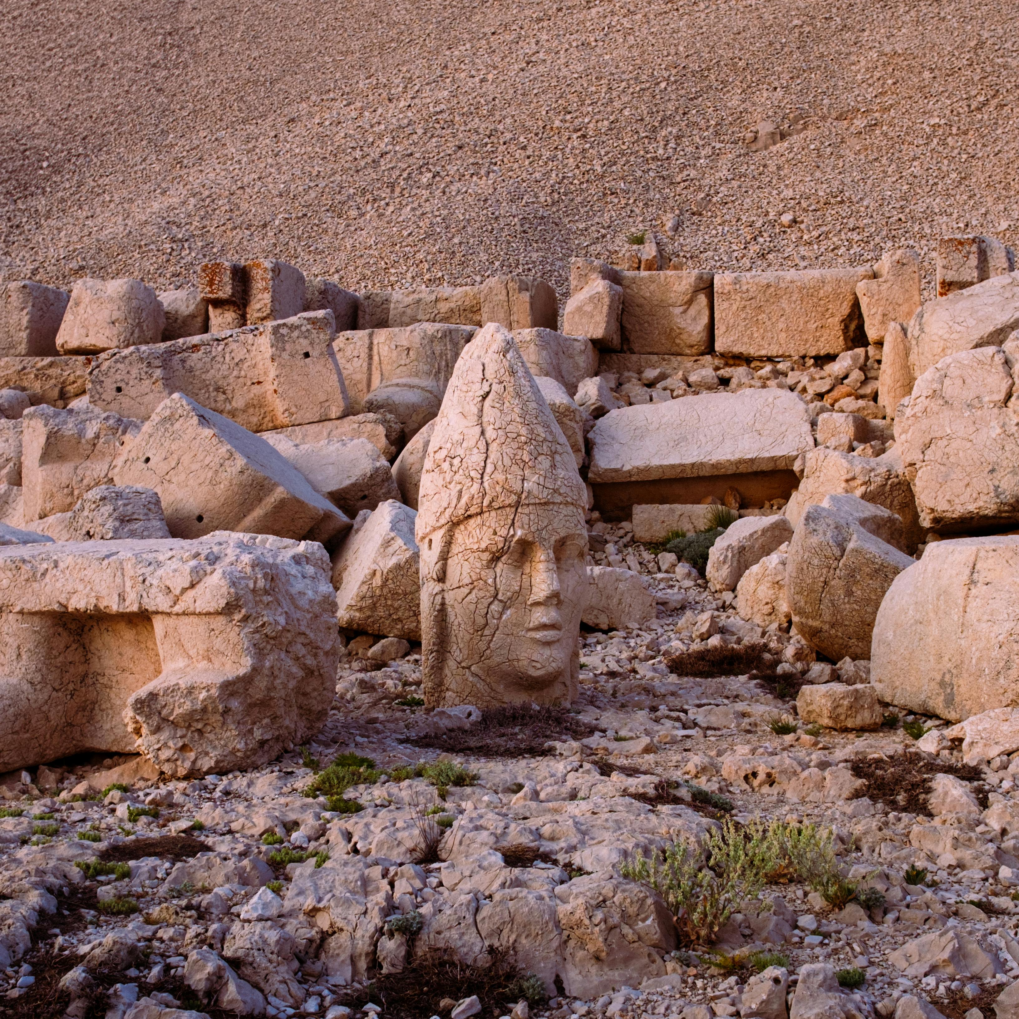 Rugged stone statues and headpieces from ancient civilizations on Mount Nemrut.