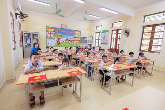 Bright classroom with children ready to learn, showcasing vibrant decor and attentive students. 33852213