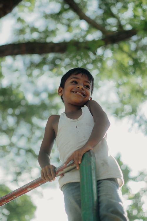 Free Smiling child enjoying a sunny day outdoors on a playground. Stock Photo