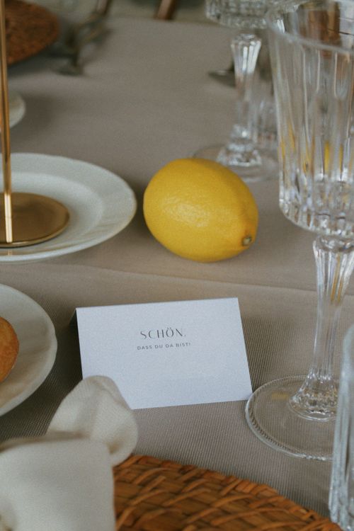 Free Stylish table arrangement with a lemon, crystal glass, and card on a linen cloth Stock Photo