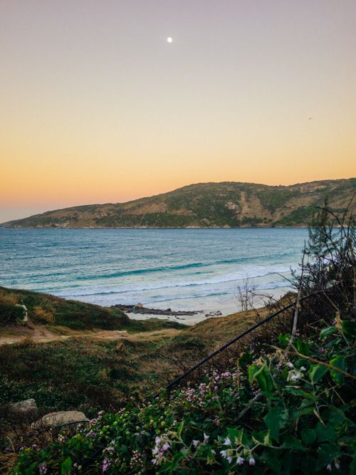 Free Captivating sunset over the serene coastline of Búzios, Brazil, with lush greenery and ocean view. Stock Photo