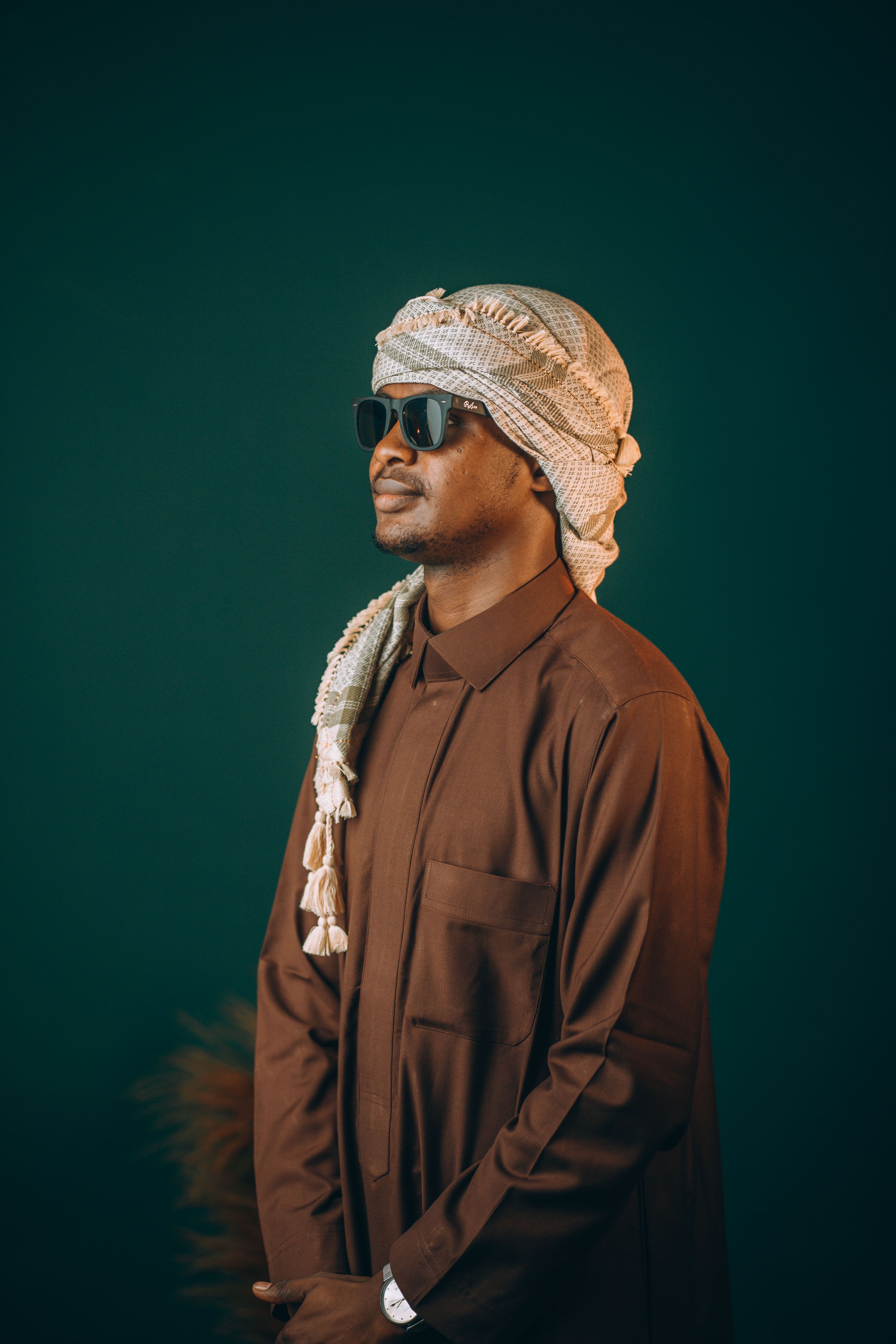Side profile of a man in traditional Middle Eastern attire with sunglasses.