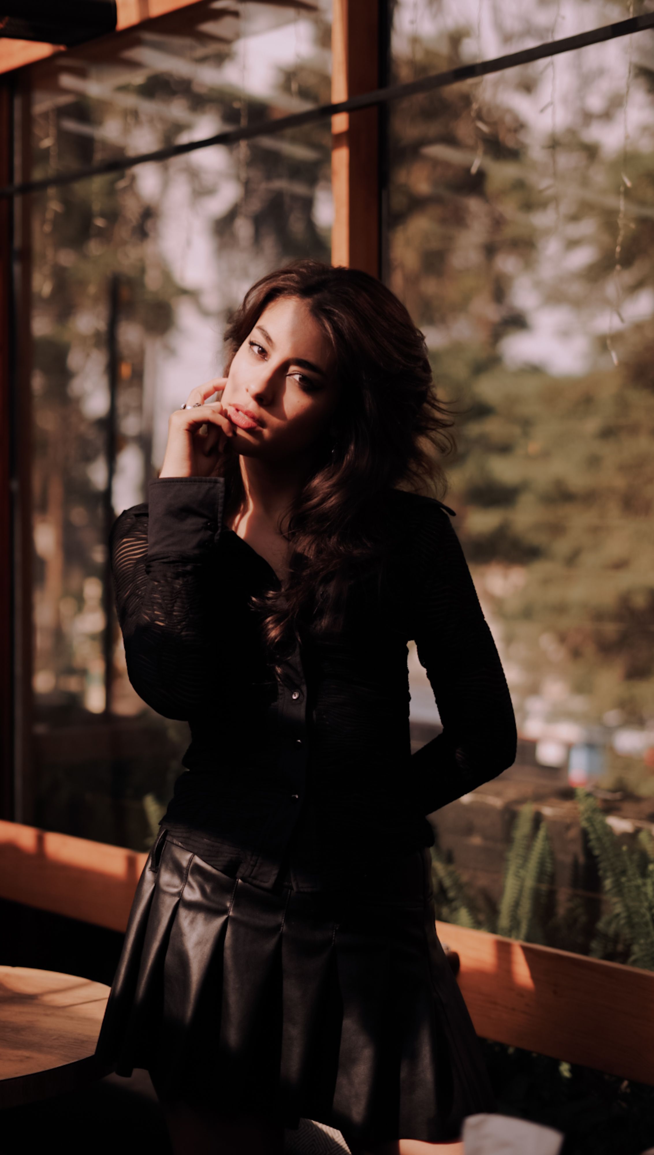 Stylish Woman Posing Indoors in Warm Light · Free Stock Photo