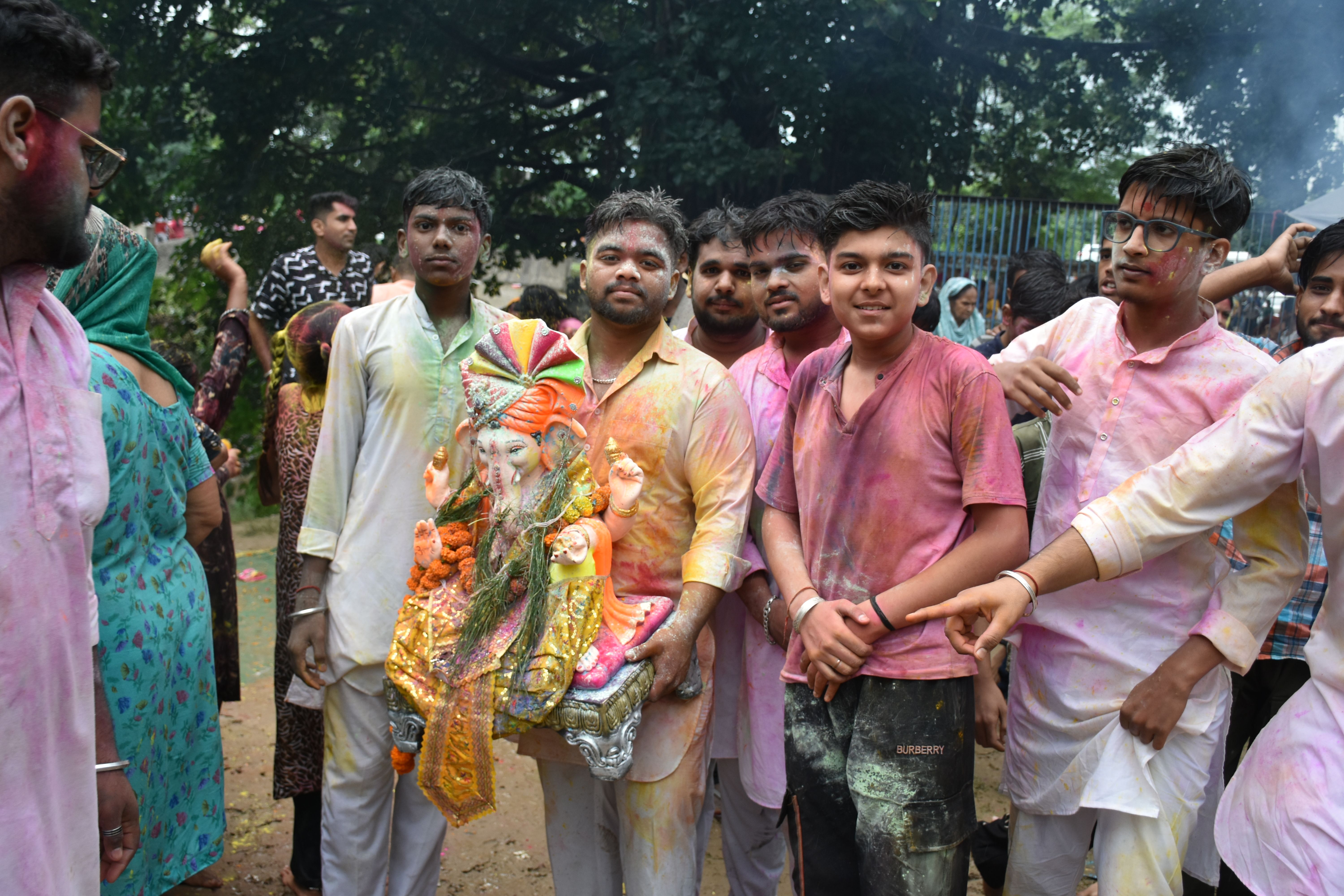 Group of young people celebrating Ganesh festival with colorful powder.