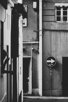 A monochrome street view with one-way sign and buildings.