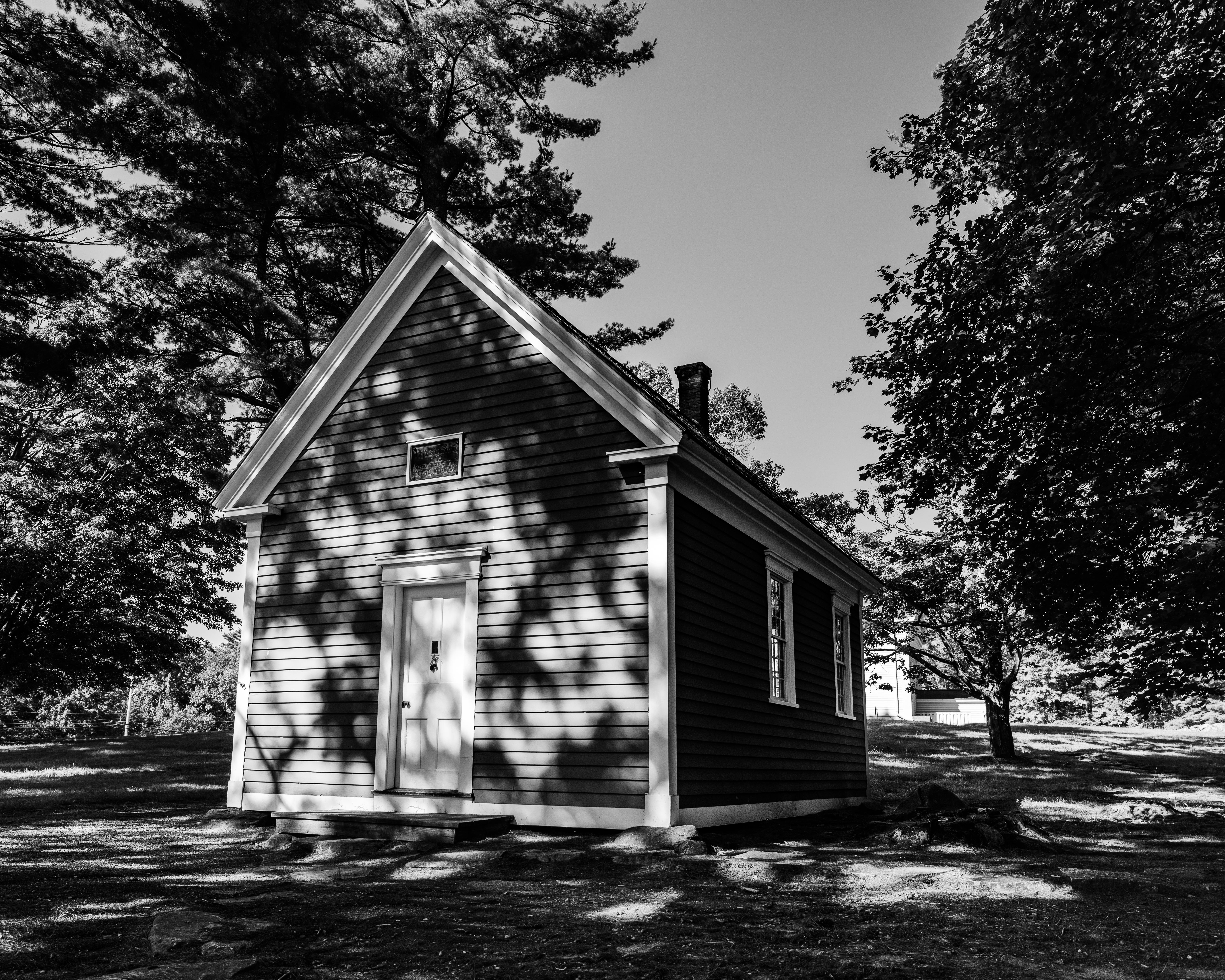 A classic one-room schoolhouse in Sudbury, Massachusetts, captured in black and white.