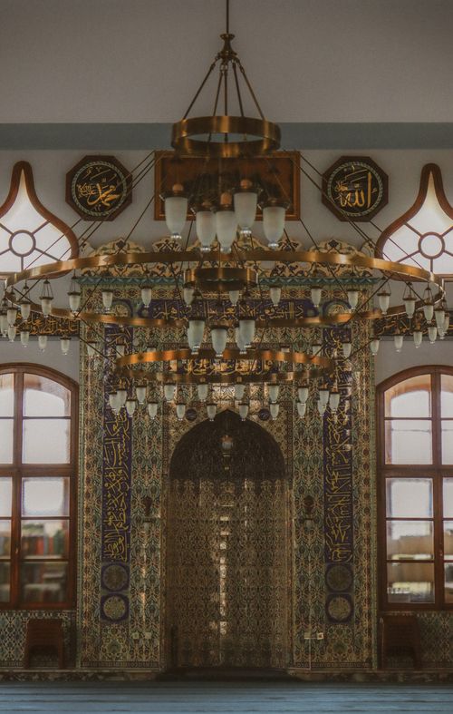 Free Beautifully detailed mosque interior showcasing traditional Islamic architecture and an ornate chandelier. Stock Photo
