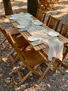Elegant outdoor dining setup with wooden tables and fall decor in Kyiv, Ukraine.