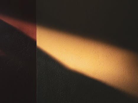 温暖的阳光在纹理墙壁上投下艺术感的阴影，营造出极简而抽象的氛围