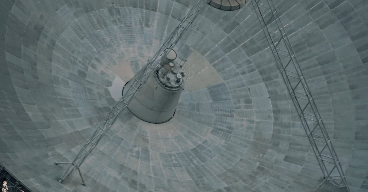 Photo by changen chan A close-up of a large satellite dish against a clear sky, showcasing technology and communication.