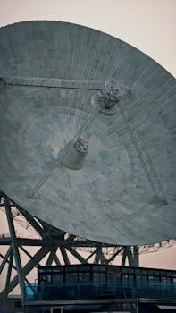 A close-up of a large satellite dish against a clear sky, showcasing technology and communication.