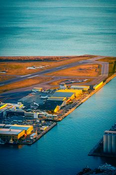 Stunning aerial view of Toronto Island Airport with golden sunset reflecting on water.