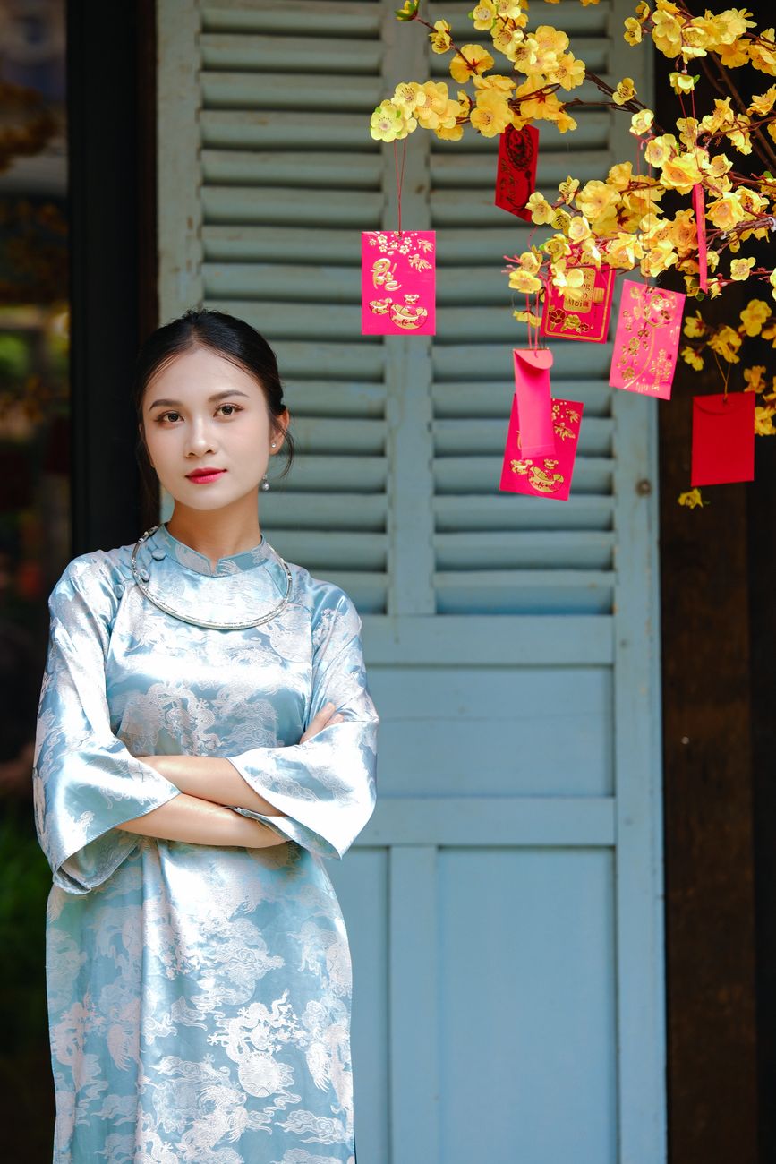 Woman in traditional Asian dress with festive decorations, exuding elegance and cultural richness.