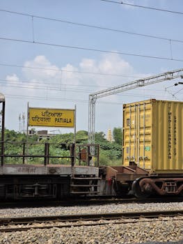 A train at Patiala Railway Station in Punjab, India with visible cargo containers.