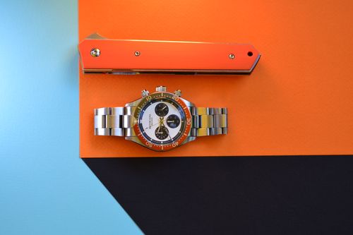 Free A sleek watch and knife on a colorful geometric background representing modern style and precision. Stock Photo