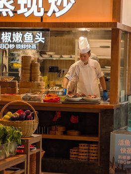 Chef skillfully prepares dishes in an Asian restaurant kitchen.