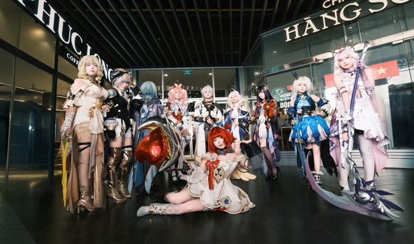 A group of cosplayers in detailed costumes posing indoors, showcasing colorful and creative character designs.