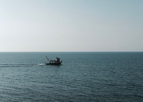 Free A solitary fishing boat sails across the calm waters of the Black Sea near Samsun, Türkiye. Stock Photo