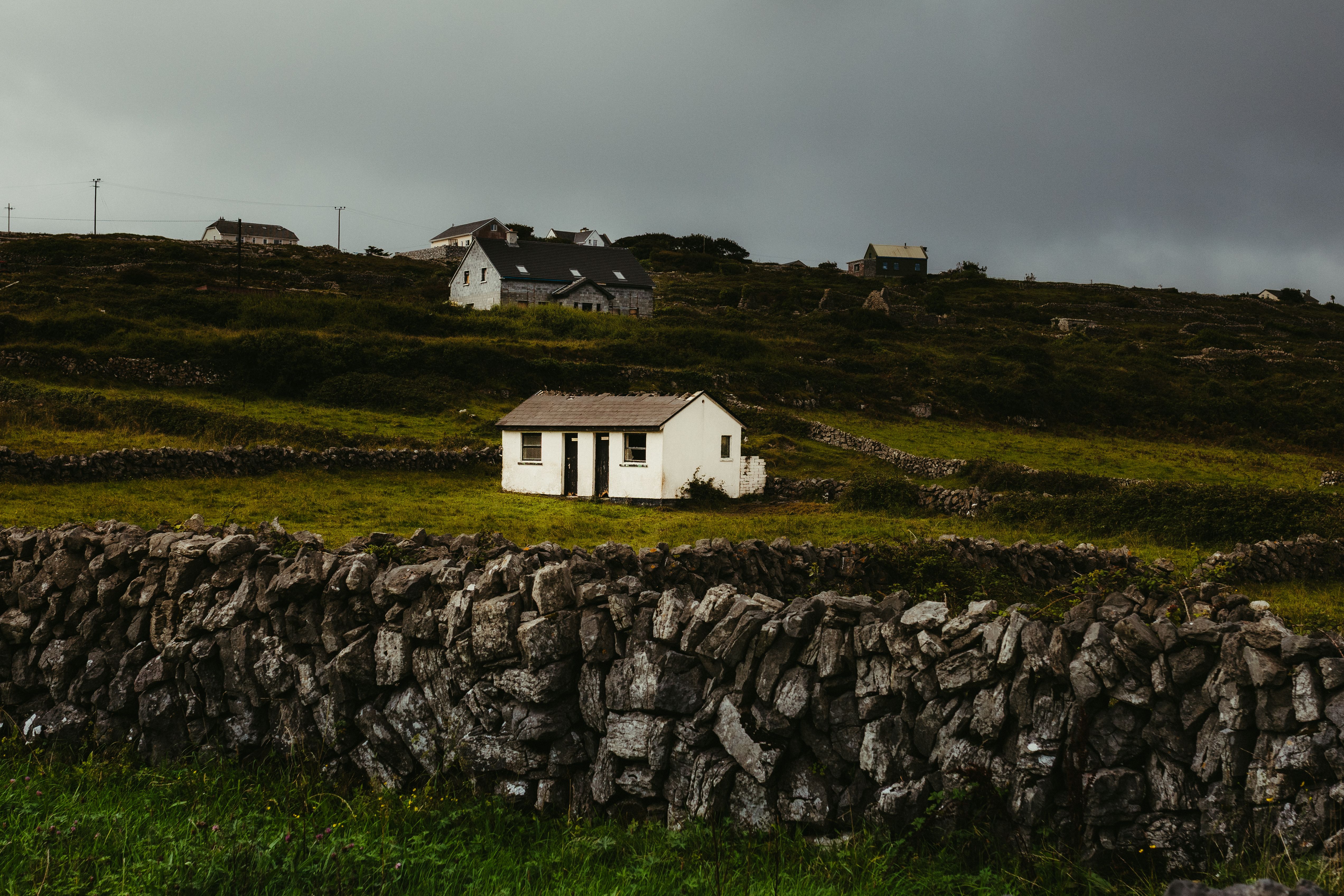 Tranquil scene of stone cottages and green fields in County Galway, showing traditional Irish architecture.