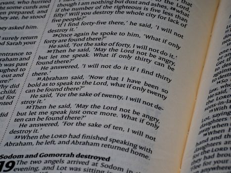 Detailed close-up of an open Bible showing the Book of Genesis text for study.