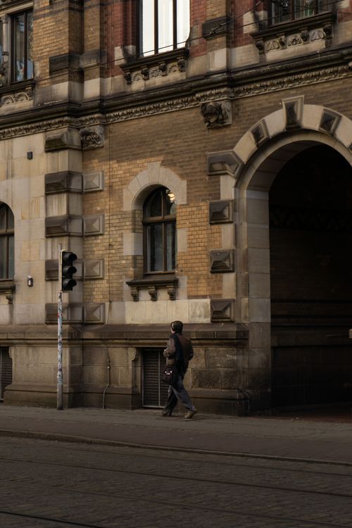 Free A person walks past historic architecture in Germany, capturing urban charm. Stock Photo
