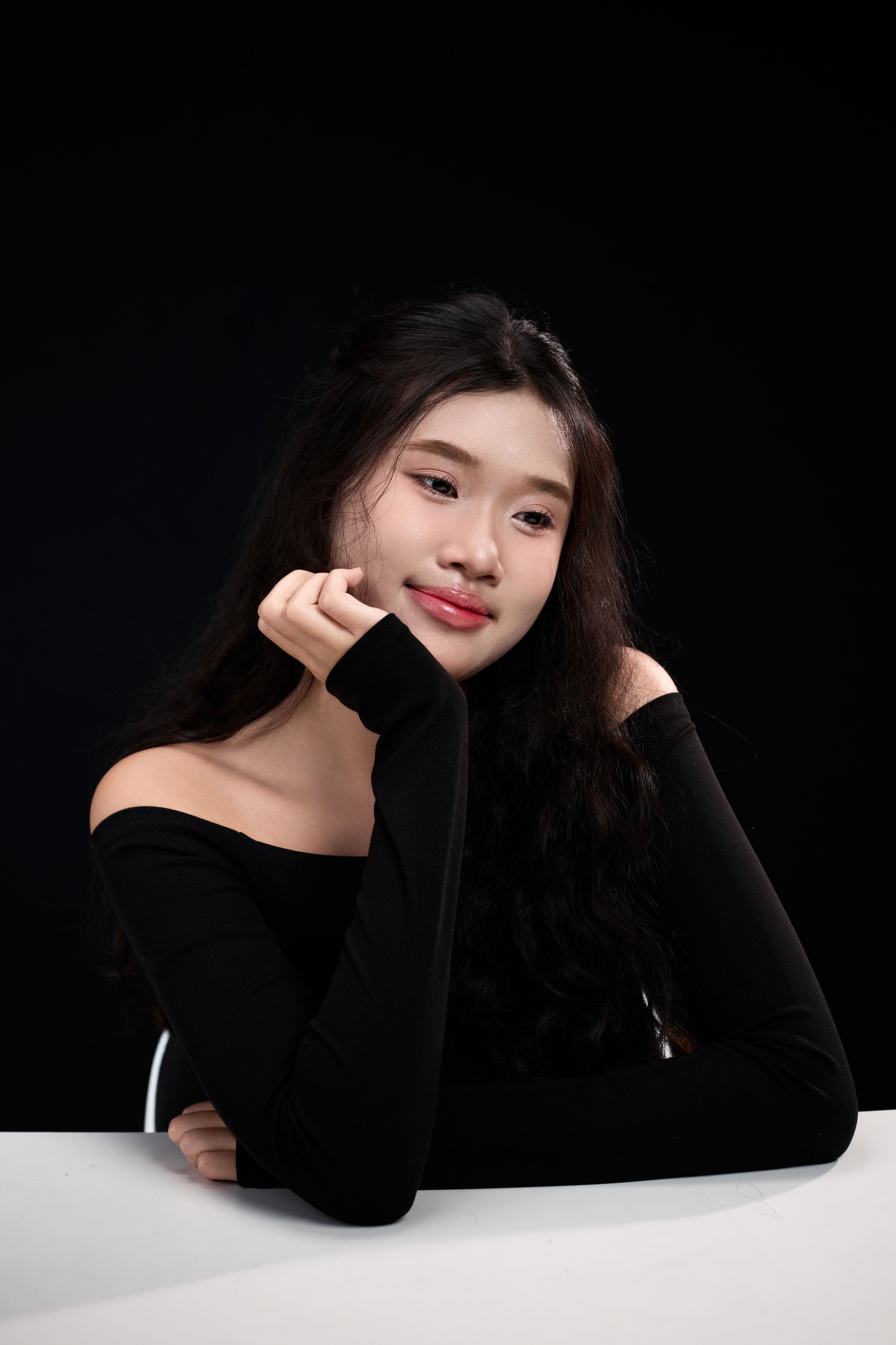 Sophisticated portrait of a woman in black attire with soft lighting.