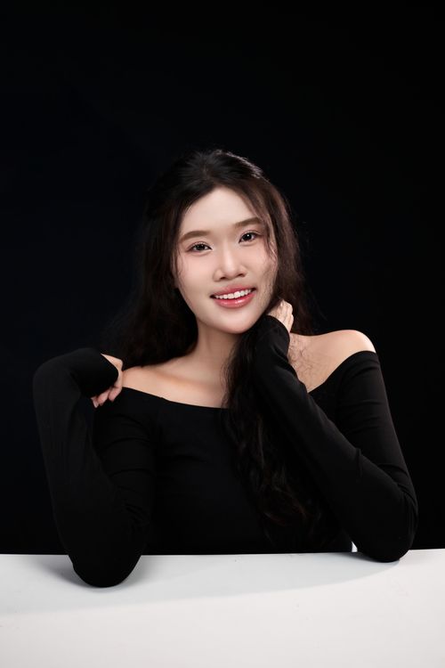 Free Charming portrait of an adult woman in a black outfit against a dark background showcasing elegance and beauty. Stock Photo