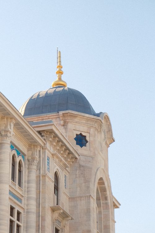 Free Beautiful stone building featuring a gold-tipped dome against a clear blue sky. Stock Photo