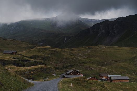 Idyllic mountain landscape with cabins in Grindelwald, Switzerland under moody clouds.