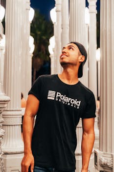 晚上，一名穿着休闲装的男子在灯光雕塑的映照下摆姿势