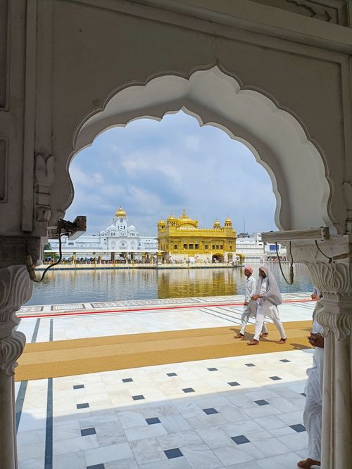 Free A view of the Golden Temple in Amritsar, Punjab, India, framed by an archway. Stock Photo