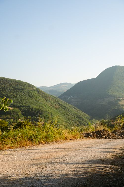 Free Serene view of green valleys and mountains under clear blue skies in summer. Stock Photo