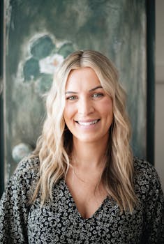 A natural light portrait of a smiling woman with wavy blonde hair for professional branding.