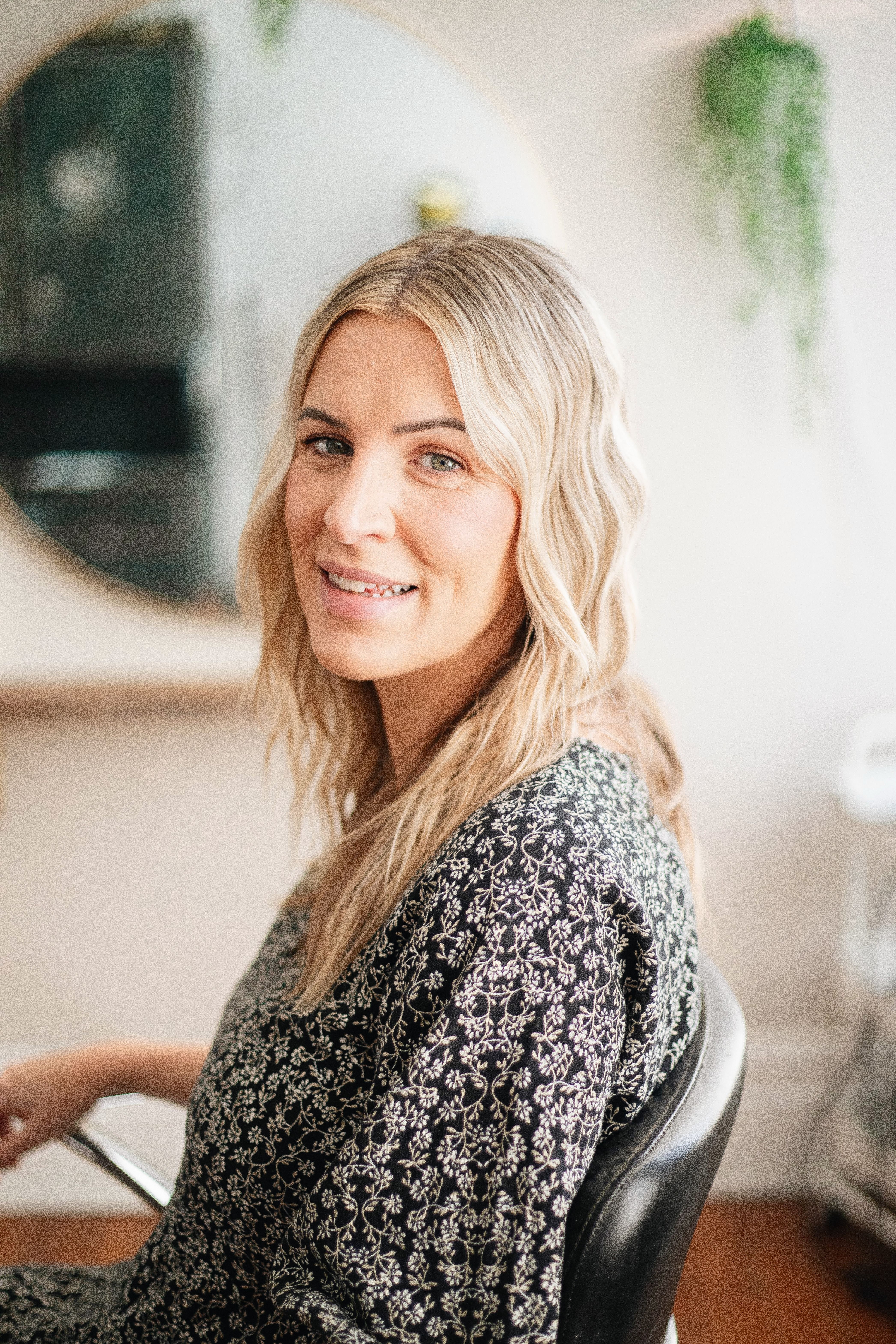 Lifestyle portrait of a woman with blonde hair in a salon, capturing natural beauty.