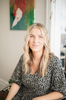 Candid portrait of a female hairstylist in a salon setting, showcasing natural beauty and professionalism.