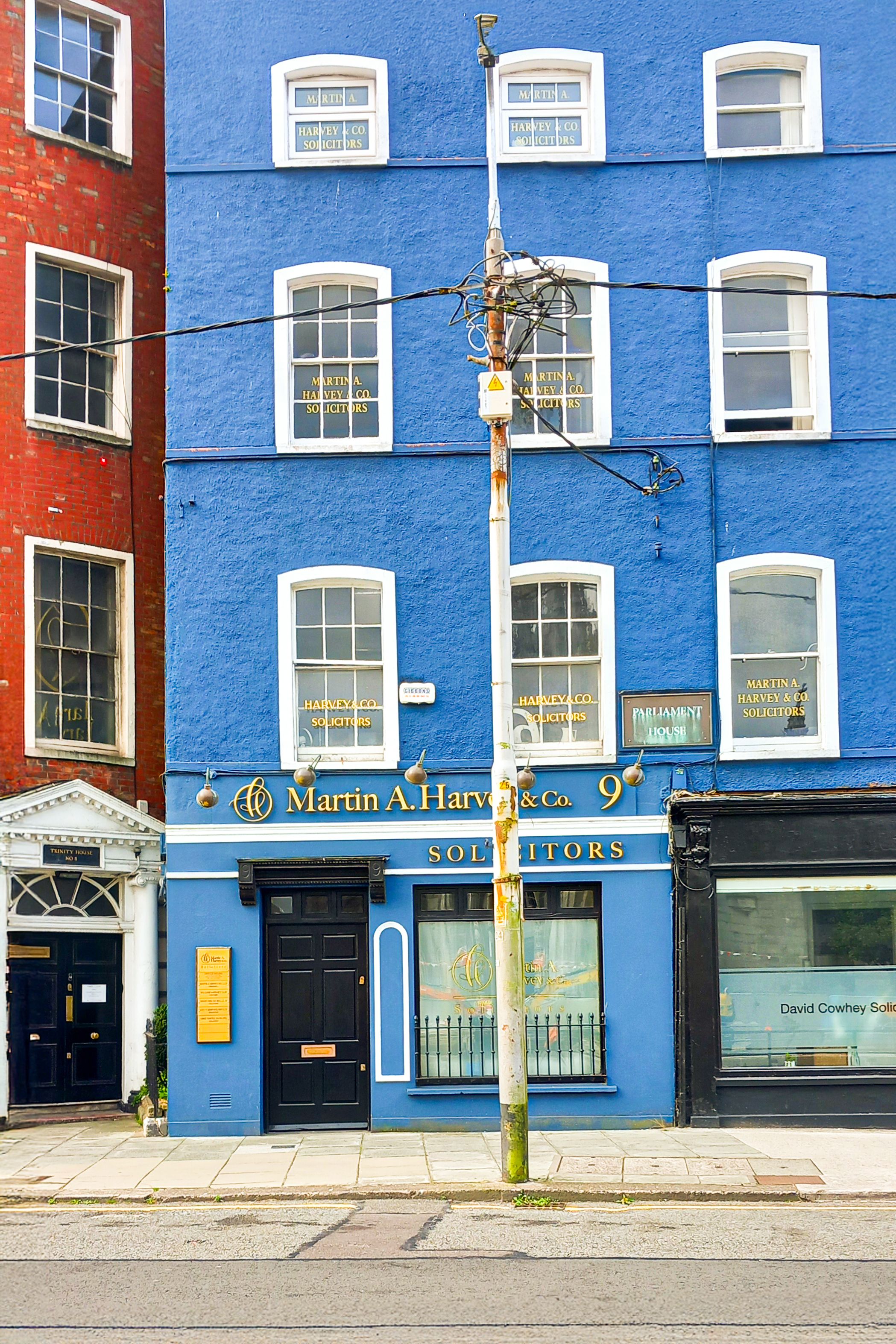 Vibrant blue and red office building facade in Dublin, showcasing classic city architecture.