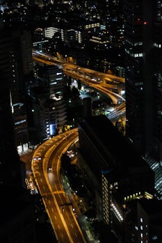 Aerial view of Tokyo at night highlighting beautifully lit highways and towering skyscrapers.