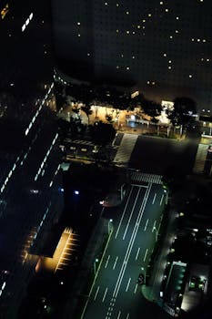 Aerial view of Tokyo city streets illuminated at night, capturing urban architecture and lighting.