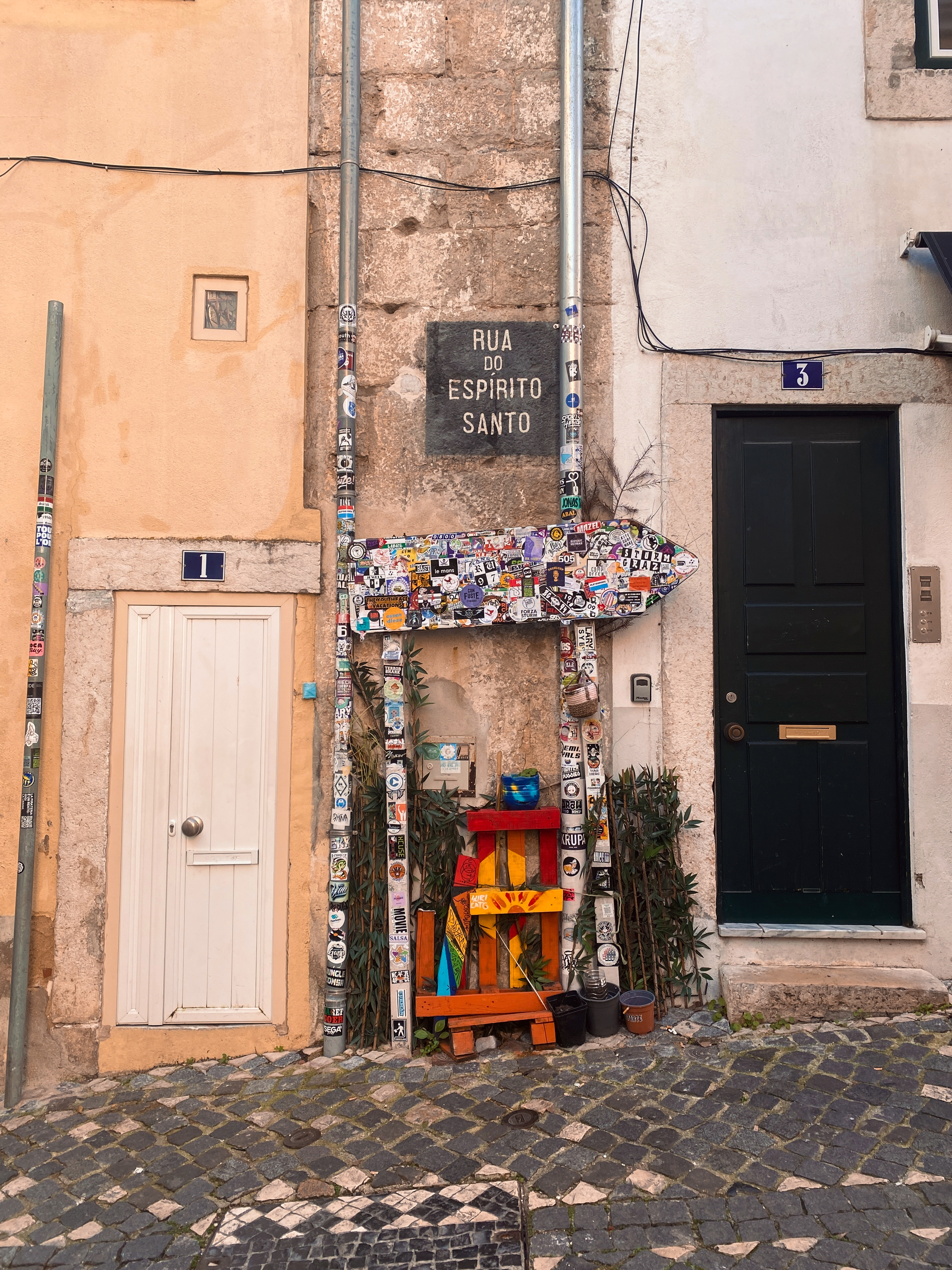 Vibrant street view featuring Rua do Espirito Santo in Lisbon with colorful signs and doors.