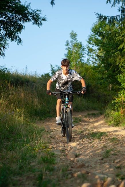 Young male mountain biking on rugged forest path in Sărămaș, România.