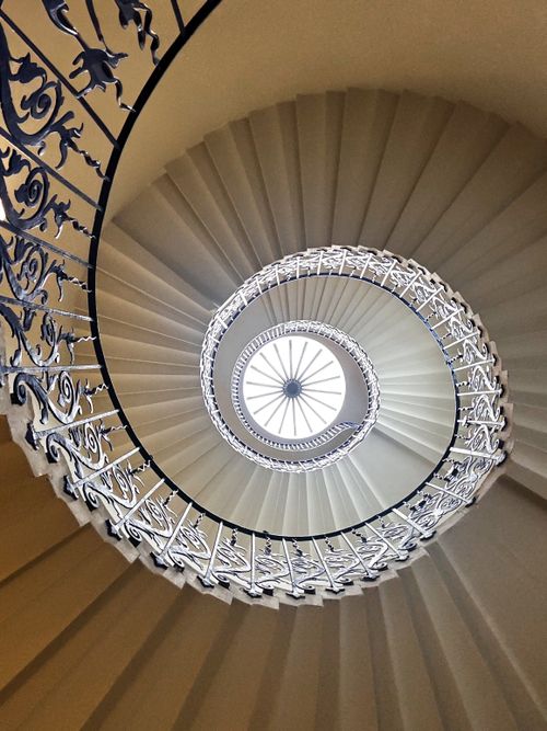 Free Upward view of a beautifully crafted spiral staircase with intricate railing details. Stock Photo