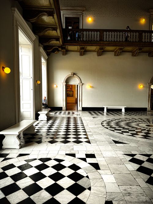 Free Stunning marble hallway with checkered floor and vintage lighting, ideal for architectural design inspiration. Stock Photo